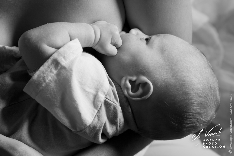 Séance photo pour une naissance, portrait d'un bébé qui taite le sein de sa mère