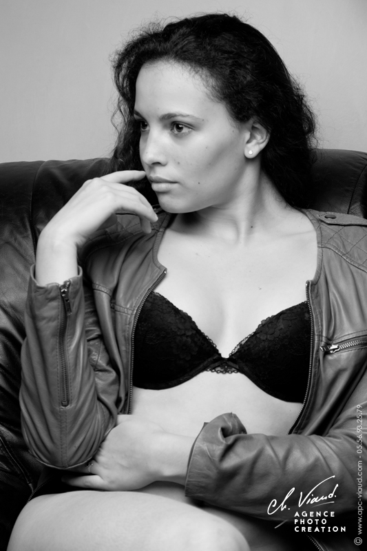 Portrait de charme d'une femme dans un canapé en sous vêtements avec un blouson en cuir