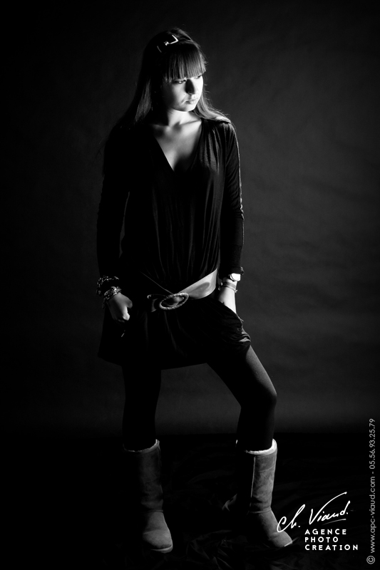Portrait plein pied en noir et blanc d'une jeune femme dans un studio photos