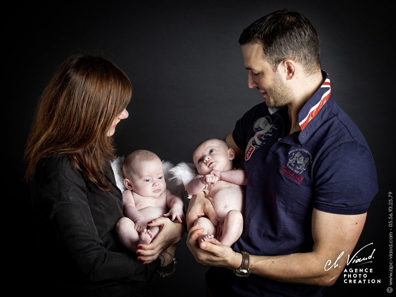 Portrait studio d'une famille avec les parents et leur nouveau-nés dans les bras