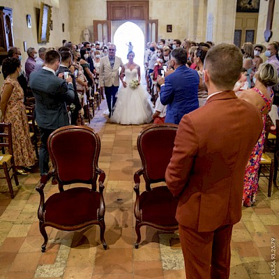 Reportage mariage - Photo du marié dans l'église regardant sa future épouse avancer