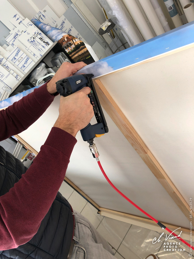 Pose d'agrafes pour fixer l'impression photo sur toile